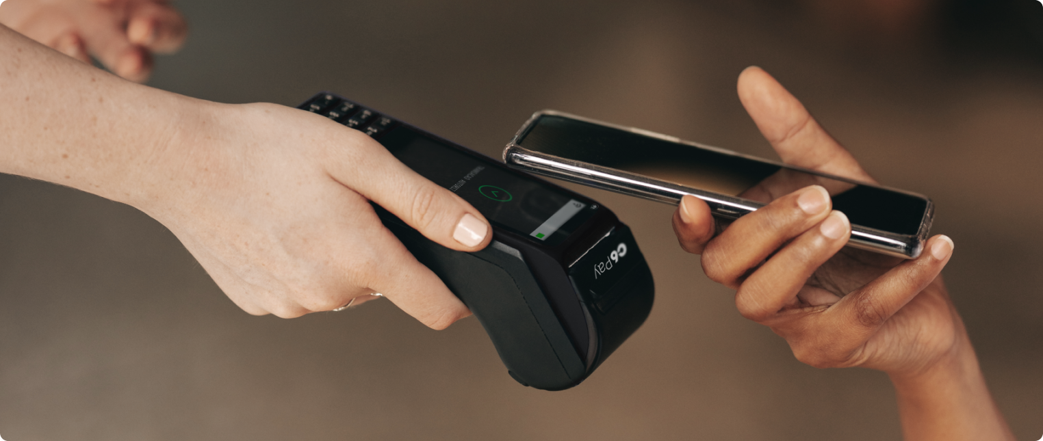 Pessoa realiza pagamento por aproximação com celular em maquininha.