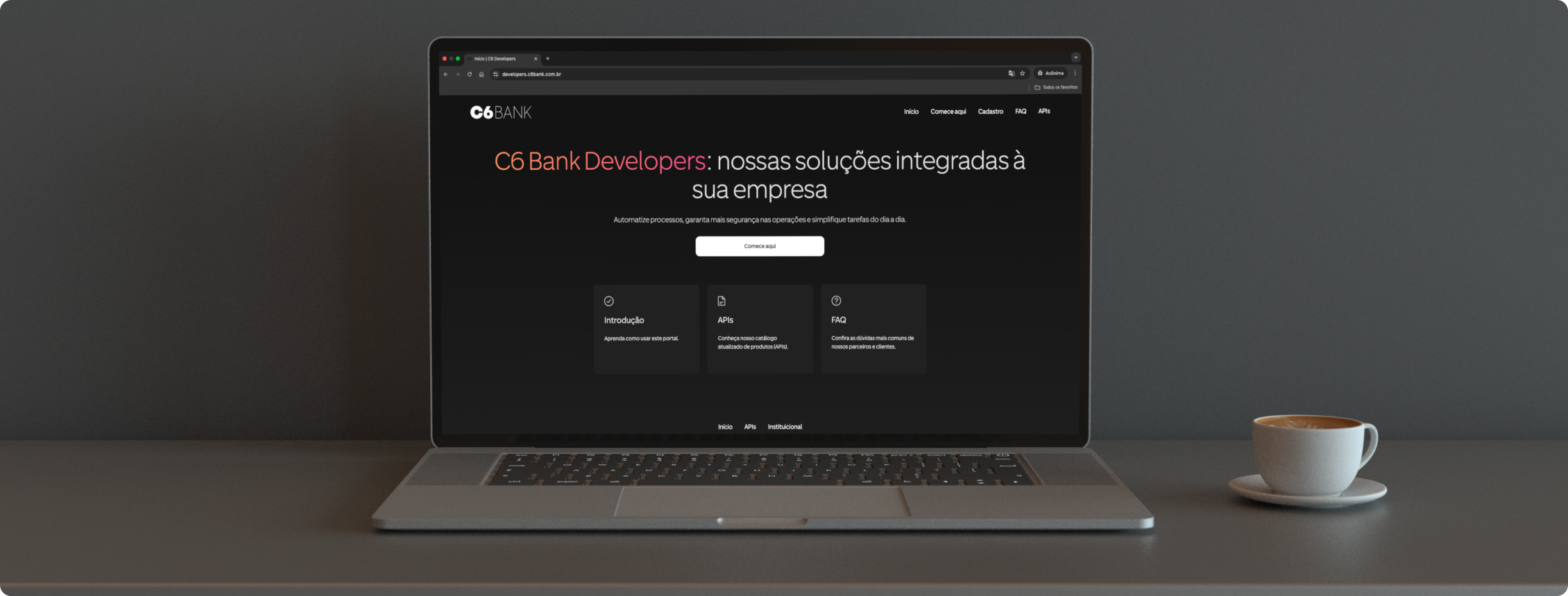 Notebook exibe o portal C6 Bank Developers; ao lado, uma xícara de café.