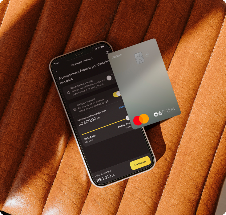Cartão C6 Platinum ao lado de celular com o app do C6 Bank na área de troca de pontos.