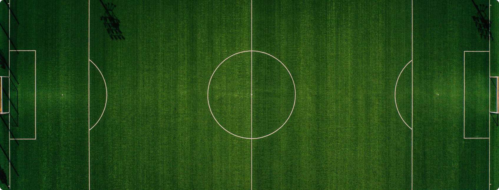 Imagem aérea de campo de futebol iluminado.