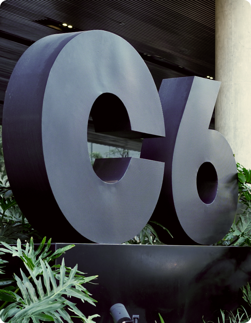 Fotografia do logo do C6 Bank, exposto em frente à sede do banco.