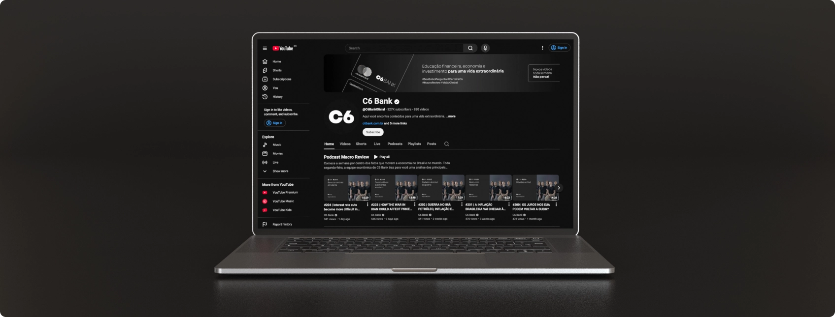 Notebook mostra o canal do C6 Bank no YouTube, com banner, menu lateral e vídeos do podcast “Macro Review” em destaque.
