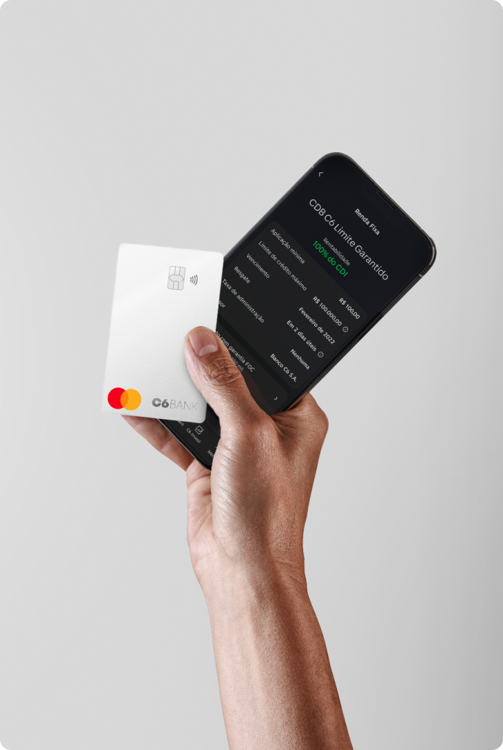 Mão segura cartão C6 Silver e celular com app exibindo aplicação em CDB com limite garantido.