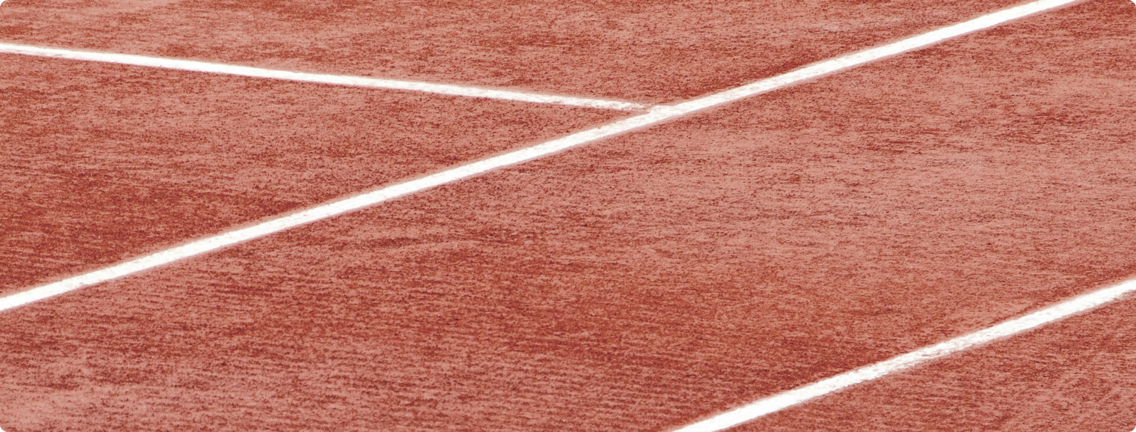 Fotografia de quadra de tênis com piso vermelho.