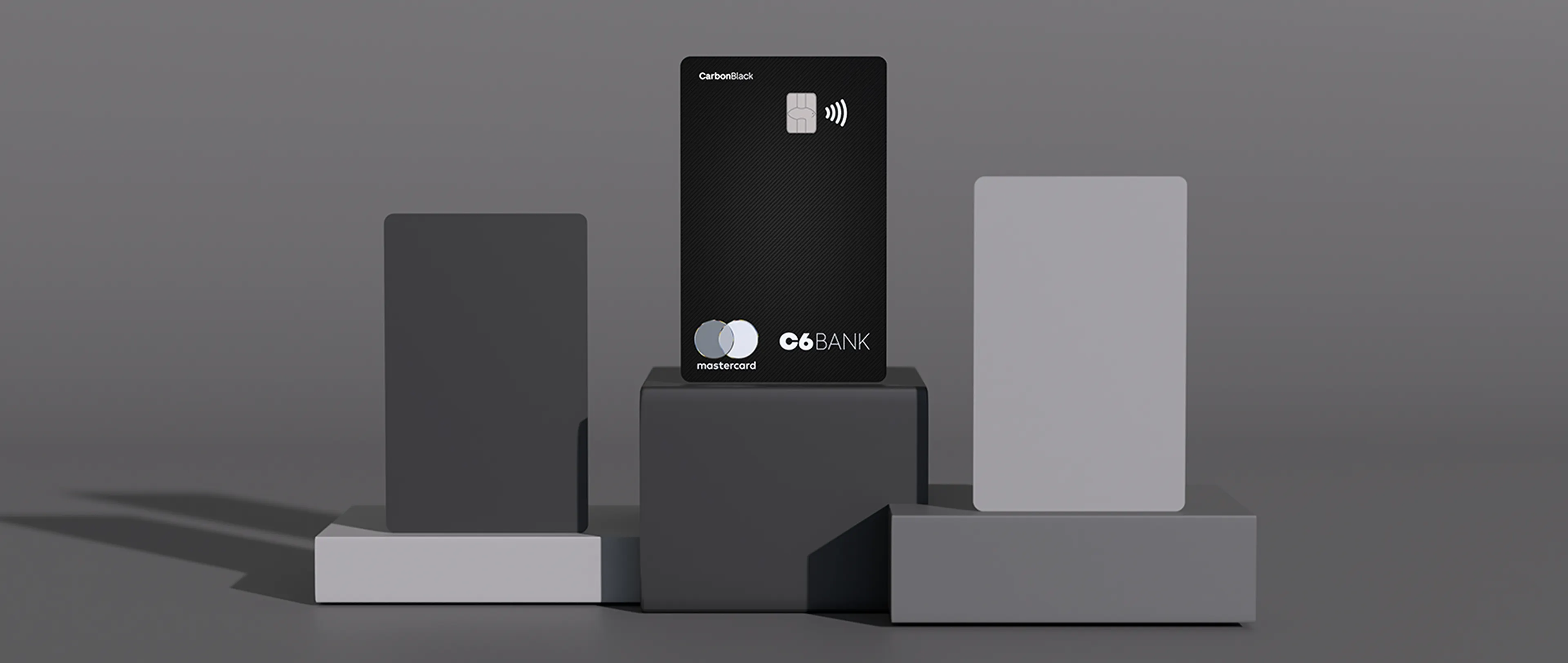 Cartão C6 Carbon no topo de um pódio cinza minimalista.
