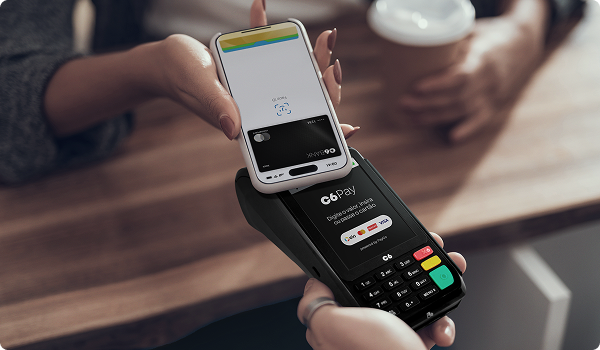 Celular realiza pagamento por aproximação em maquininha C6 Pay.