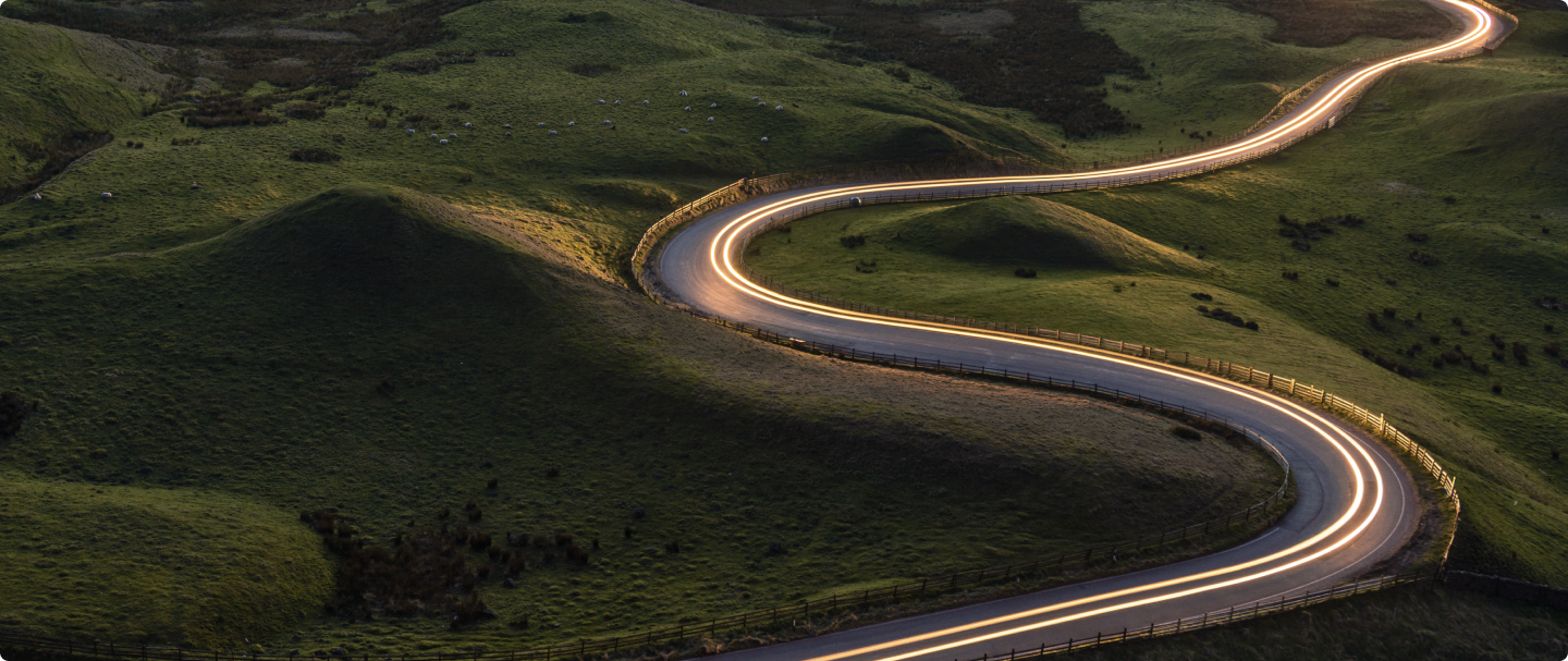 Imagem aérea de uma estrada com curvas em meio a uma montanha