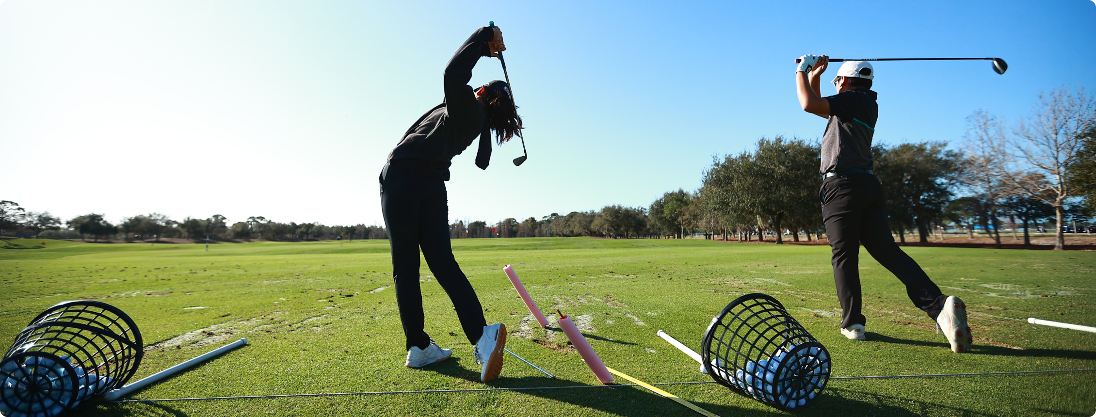 Fotografia de duas pessoas jogando golf.