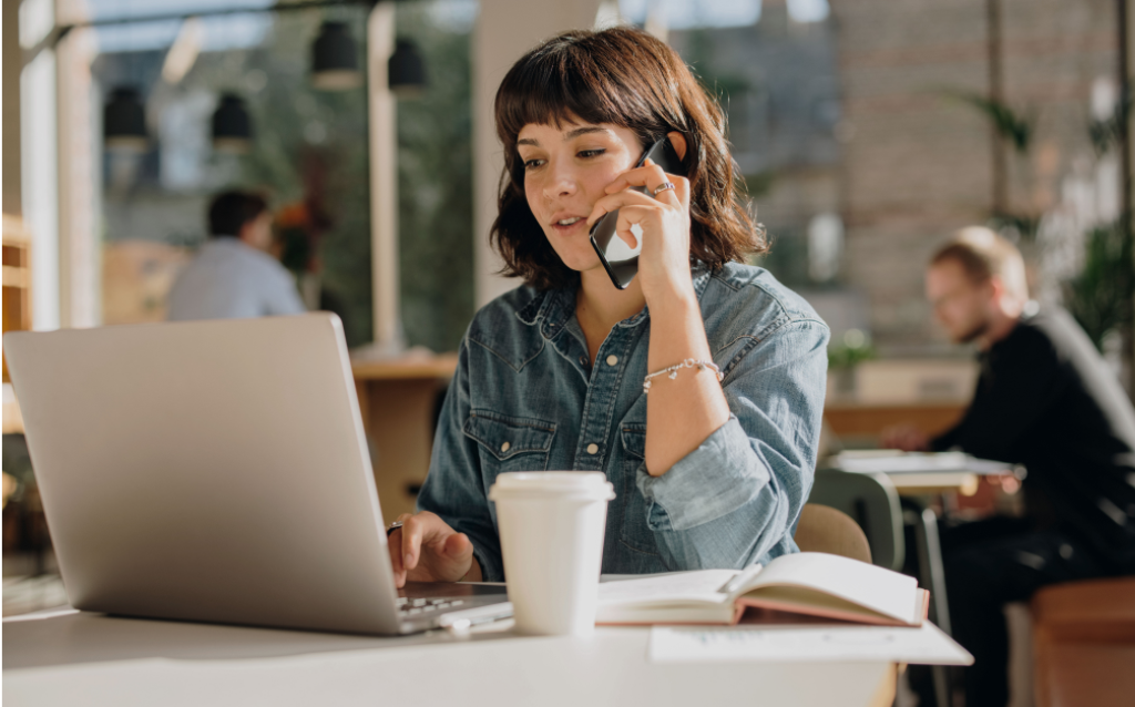 Mulher de cabelo curto, falando no celular e tendo uma boa relação com o público nas vendas através de redes sociais