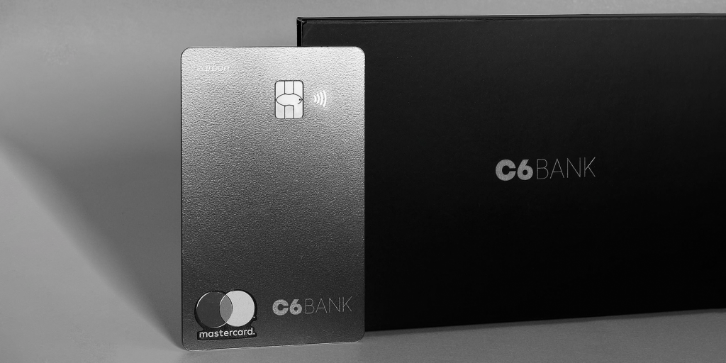 Foto de um cartão C6 Carbon apoiado na envelope em que ele é enviado para os clientes