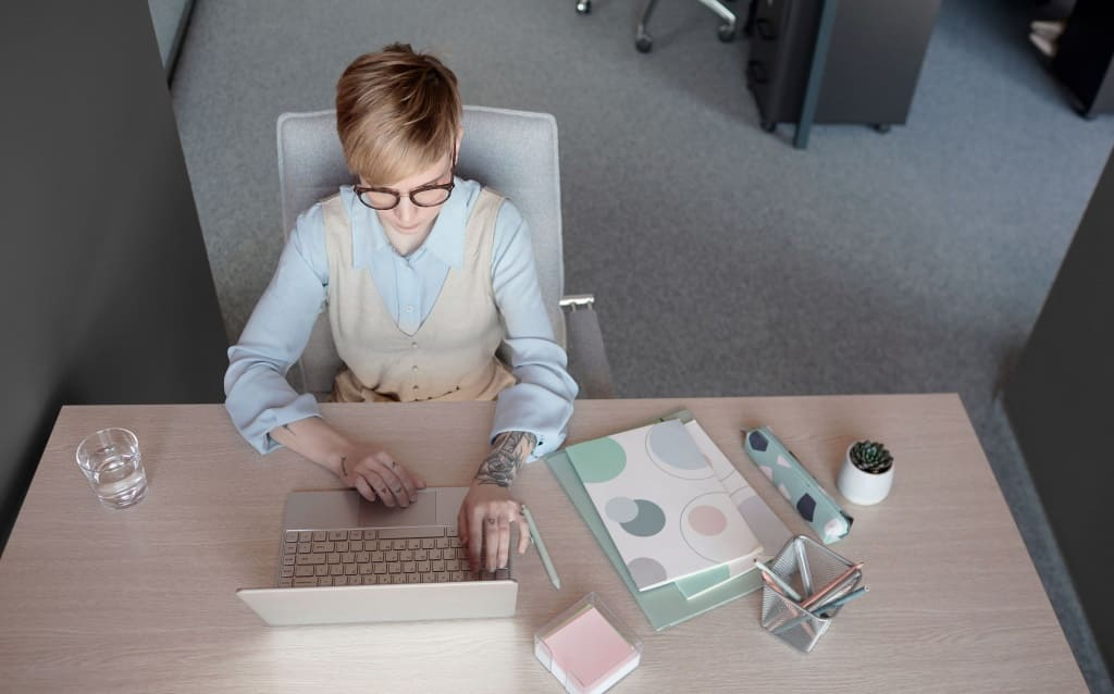 mulher loira sentada diante de computador pesquisando como calcular o valuation