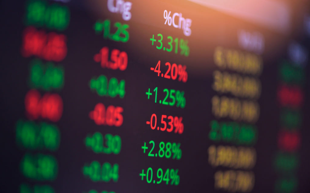 painel com diversos ativos listados apresentando queda ou ascensão, representando como investir em empresas de capital aberto