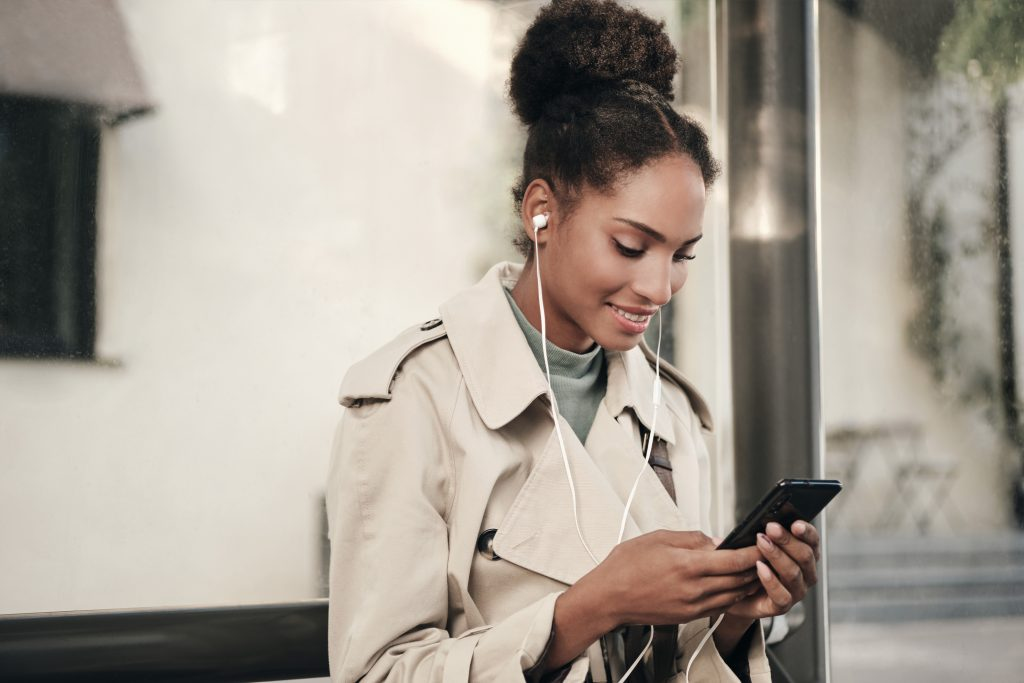 mulher negra mexendo no celular aprendendo a desbloquear o cartão c6 bank