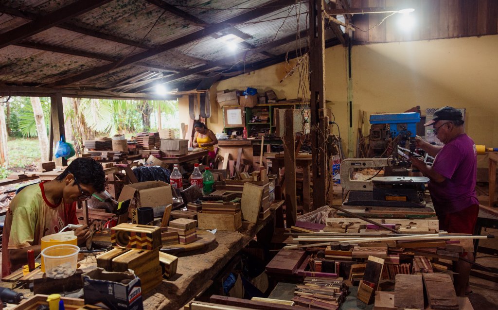 Pessoas reunidas em uma sala fazendo o artesanato da Fundação Almerinda Malaquias