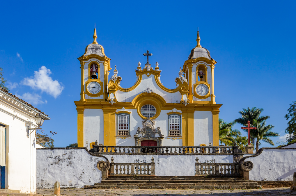 Imagem de uma igreja branca e amarela de Tiradentes.