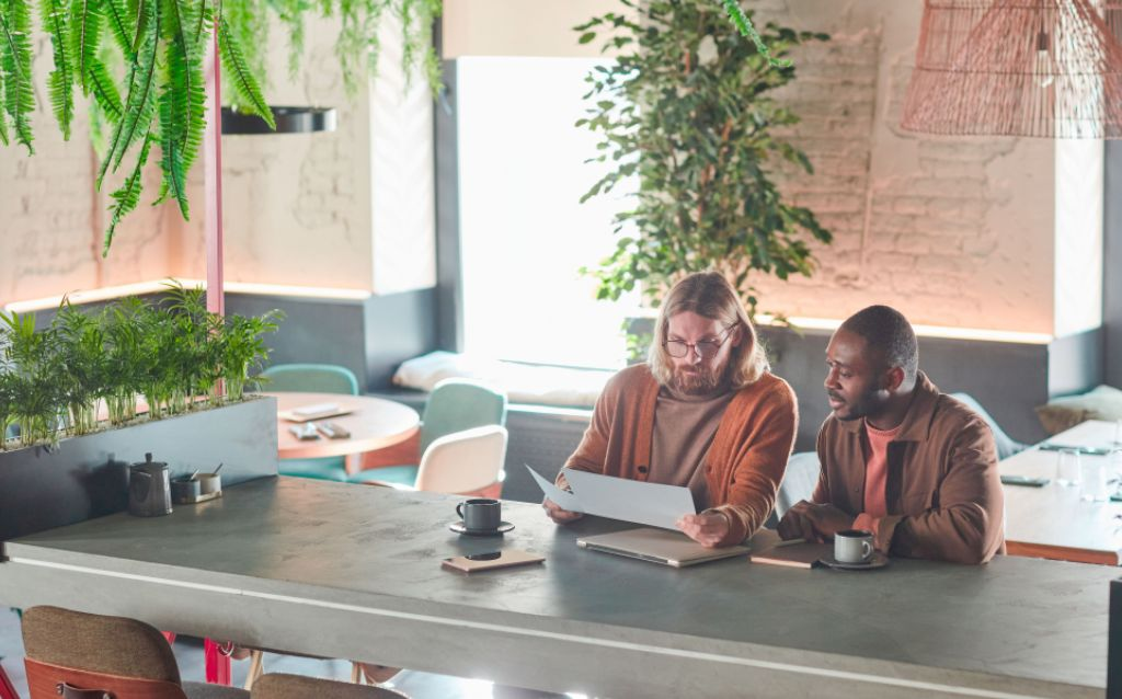 dois empreendedores em um café consultando o score de empresa cnpj