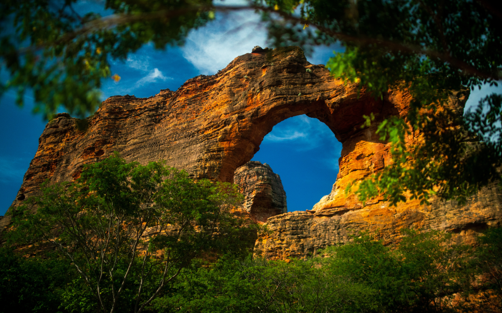   Vista do Arco da Serra da Canastra, uma formação rochosa impressionante cercada pela vegetação nativa e o céu azul, perfeito para amantes da natureza.