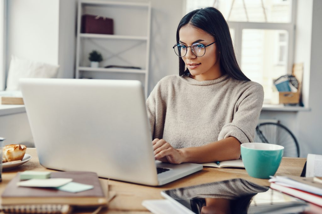mulher sentada olhando para a tela do computador