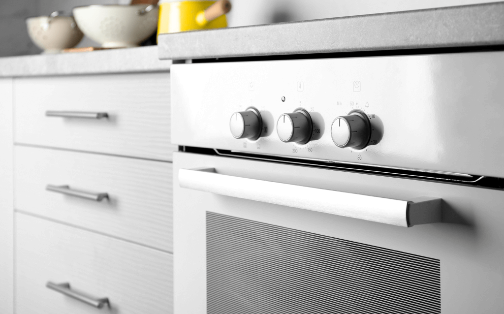 Eletrodoméstico cinza em uma cozinha ao lado de um armário