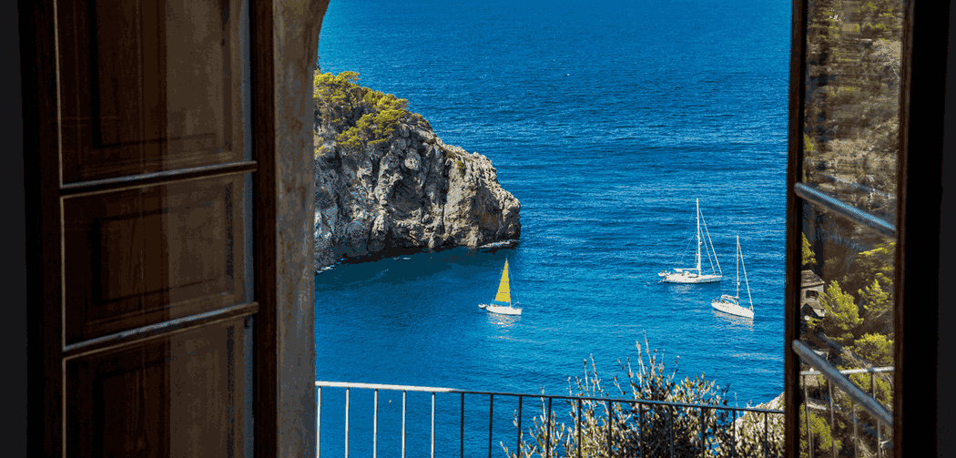 Vista de mar europeu, visto através de uma janela, representando a escolha entre pousada e hotel.