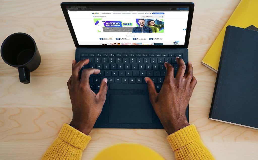 Pessoa usando notebook para acessar o site da Receita Federal, onde é possível consultar informações sobre o Imposto de Renda.