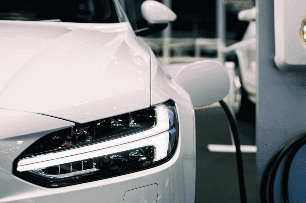 Recarga de veículo branco no posto, representando quanto custa um carro elétrico