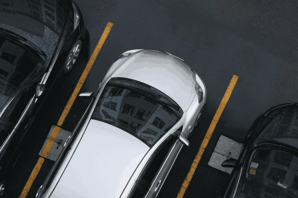 Diferentes tipos de carro estacionados lado a lado.