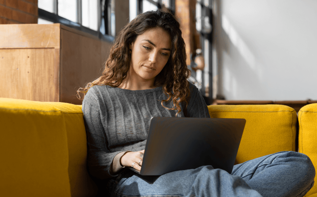 Pessoa sentada mexendo no computador pesquisando sobre transição de carreira