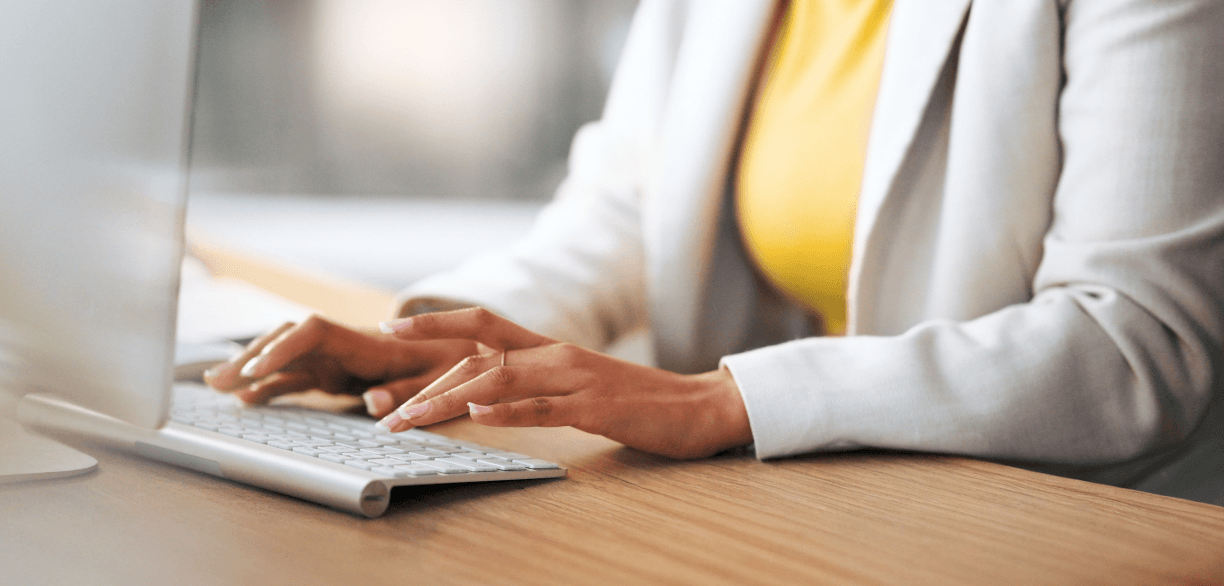 Pessoa em ambiente de trabalhando mexendo no computador