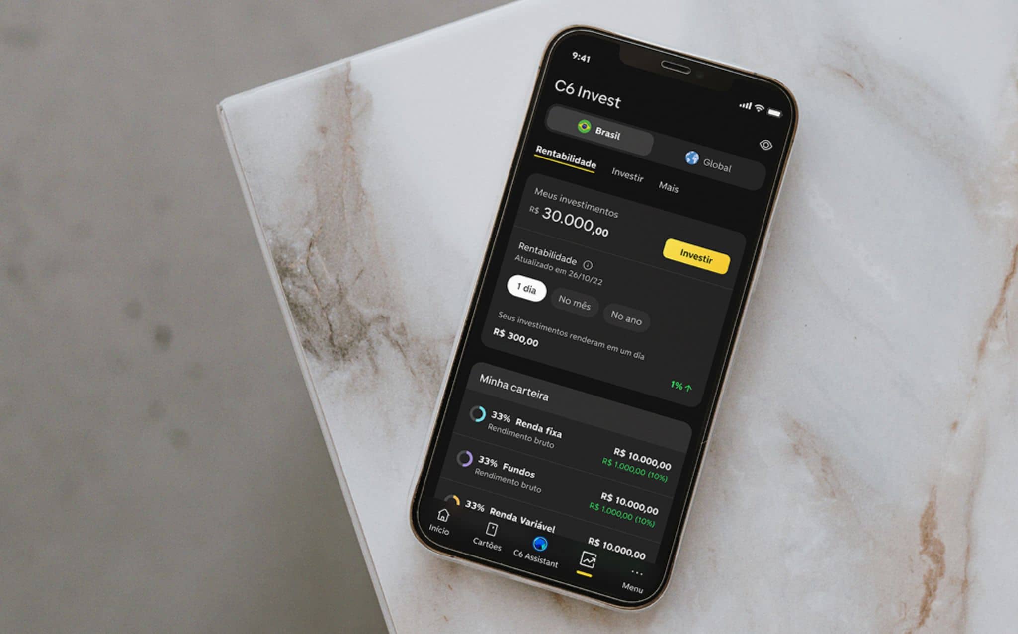 Smartphone com aplicativo C6 Invest aberto na tela de rentabilidade, exibindo carteira com renda fixa, fundos e renda variável, representando decisões de investimento para março de 2026.