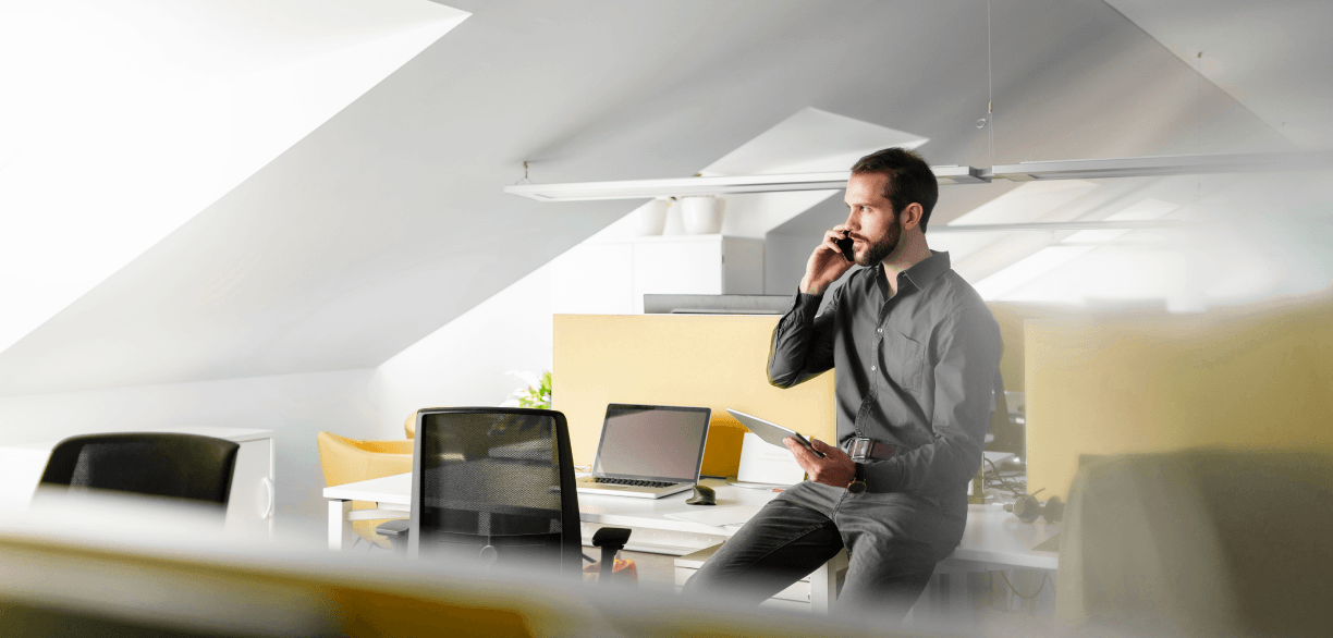Empresário em ambiente de trabalho falando ao telefone