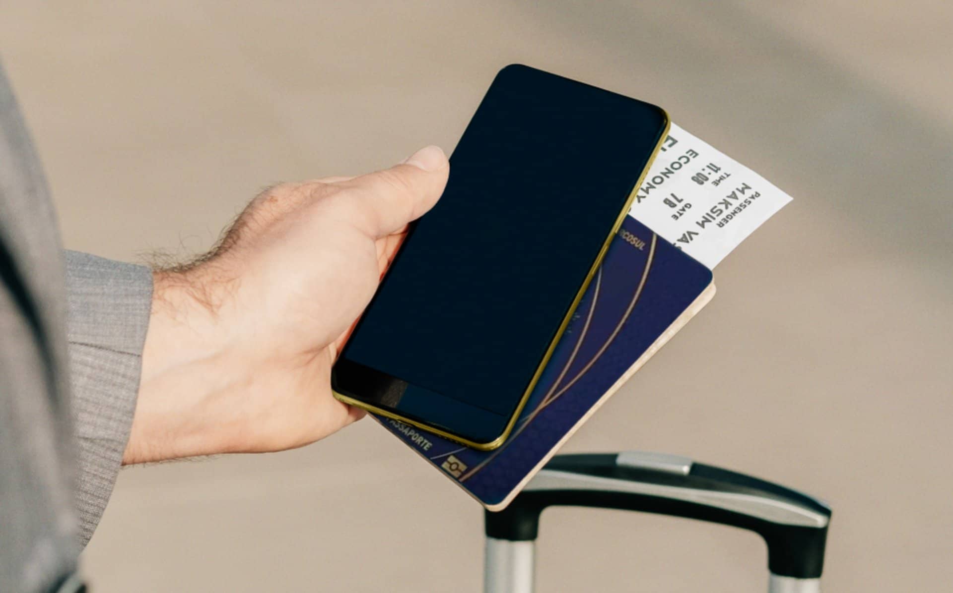 Pessoa segurando smartphone, passaporte e cartão de embarque, simbolizando solicitação e uso de visto eletrônico para viagens internacionais.