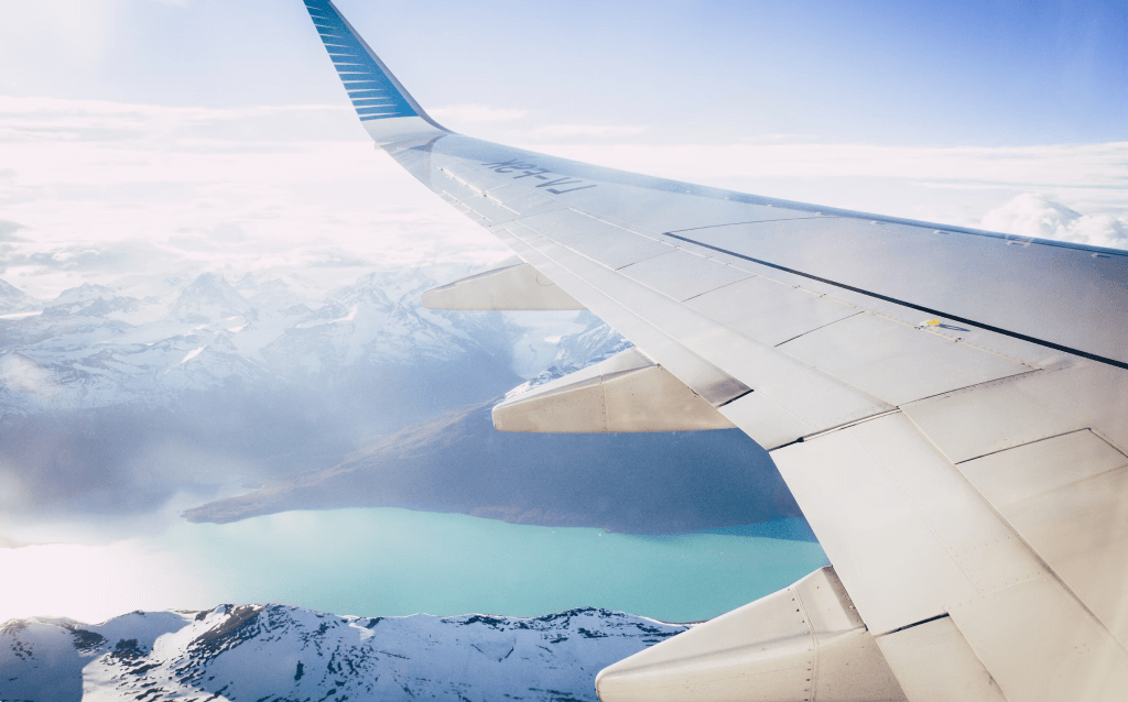 Cauda de um avião enquanto ele está voando. Paisagem com nuvens atrás