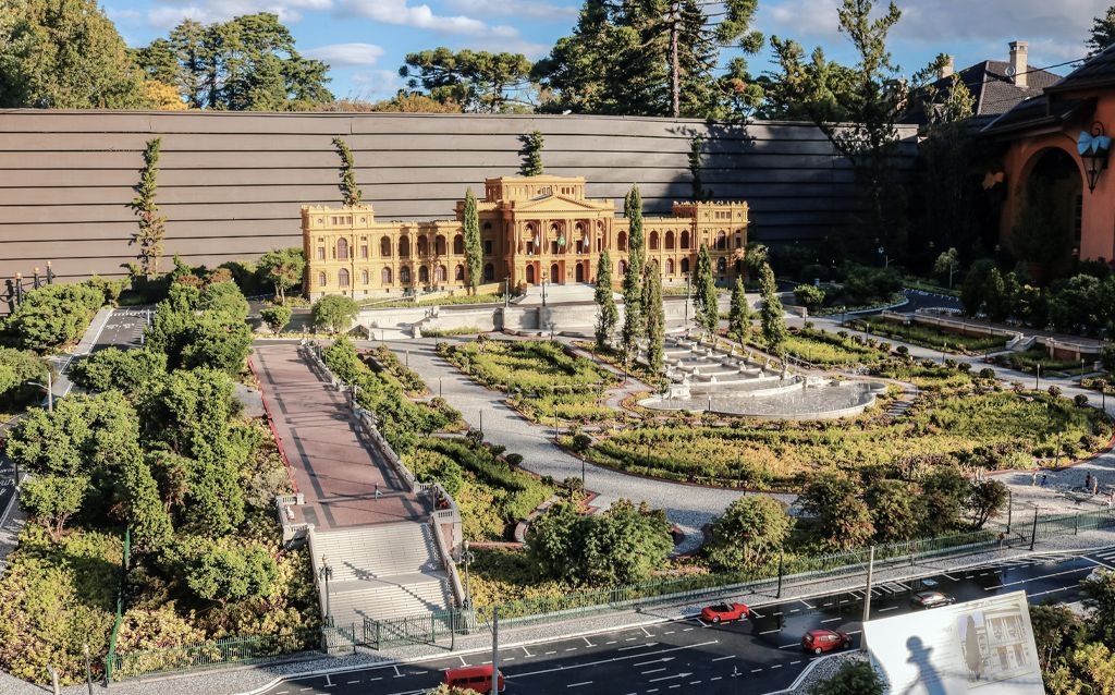 cidade em miniatura gramado com um pequeno edificio central e area com vegetação