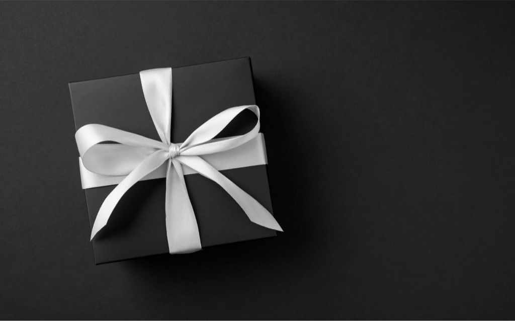 compras de fim de ano | caixa de presente preta com um laço de cetim branco