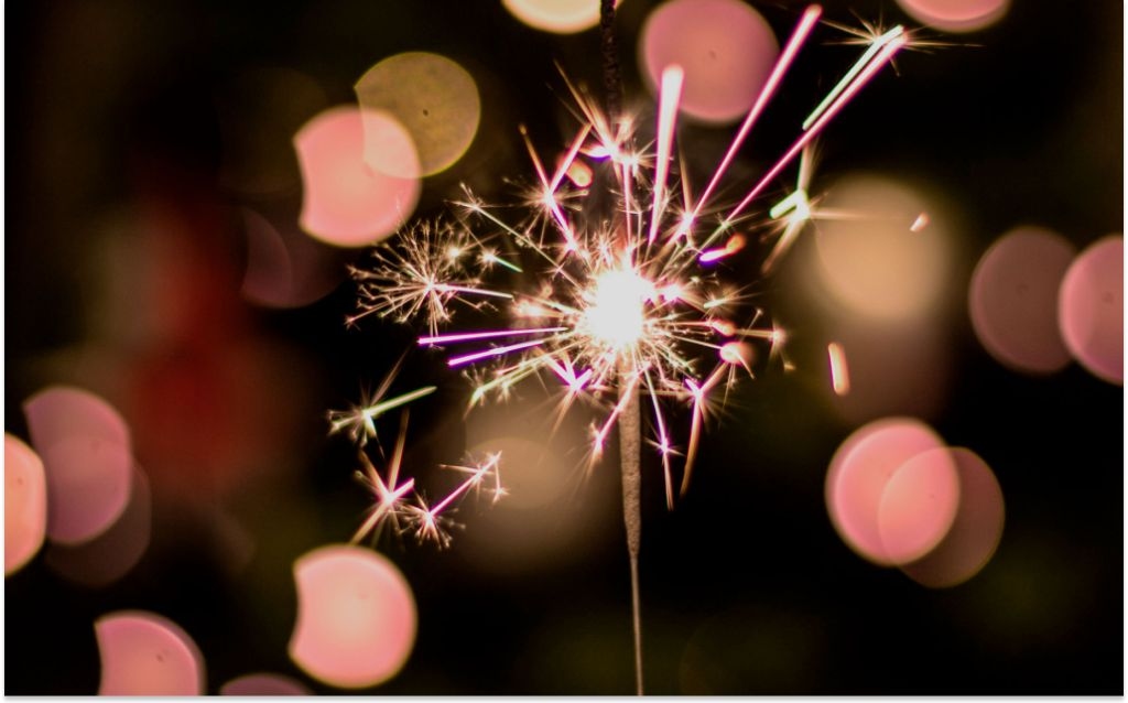 compras de fim de ano | fundo preto com luzes amarelas, vermelhas e uma vela festiva