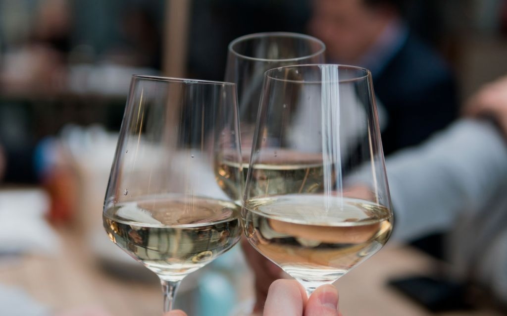 feriados de janeiro 2023 | três taças de vinho branco brindando simbolizando um novo ano