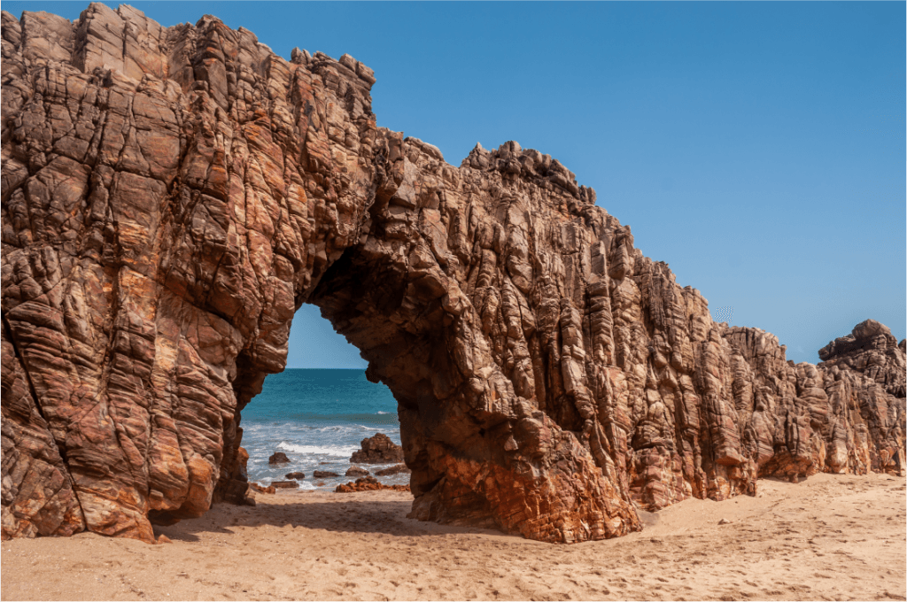 Foto de um túnel de rochas na praia de Jericoacoara.