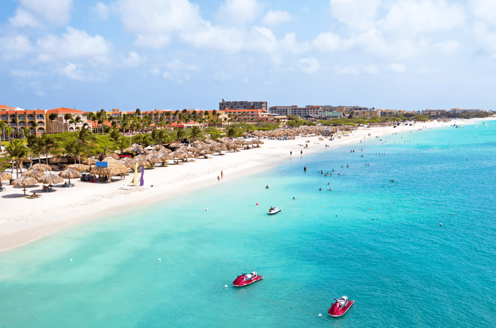 Imagem de uma praia com areia bem branca e mar bem azul em Aruba.