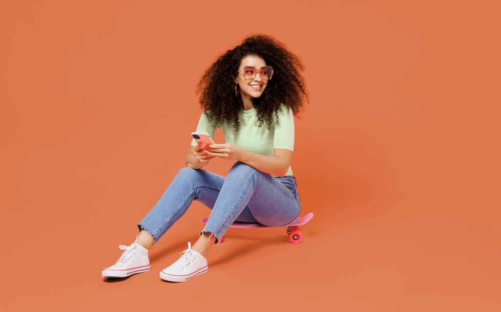 menina-adolescente-de-cabelos-crespos-sentada-sobre-um-skate-movimentando-seus-investimentos