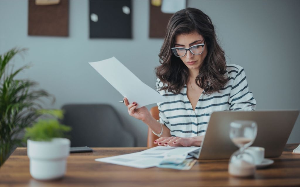 novo mercado | empresas listadas | mulher mexendo em papeis em um escritório