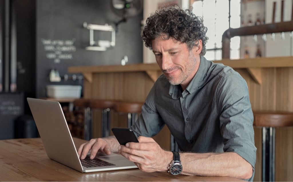 o que é pessoa pep | homem branco grisalho mexendo em um celular em um café