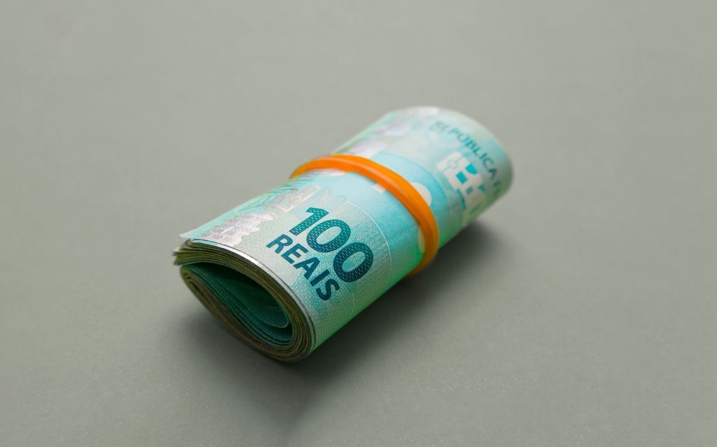 teto de gastos compras de fim ano | cédulas de cem reais amarradas com um laço
