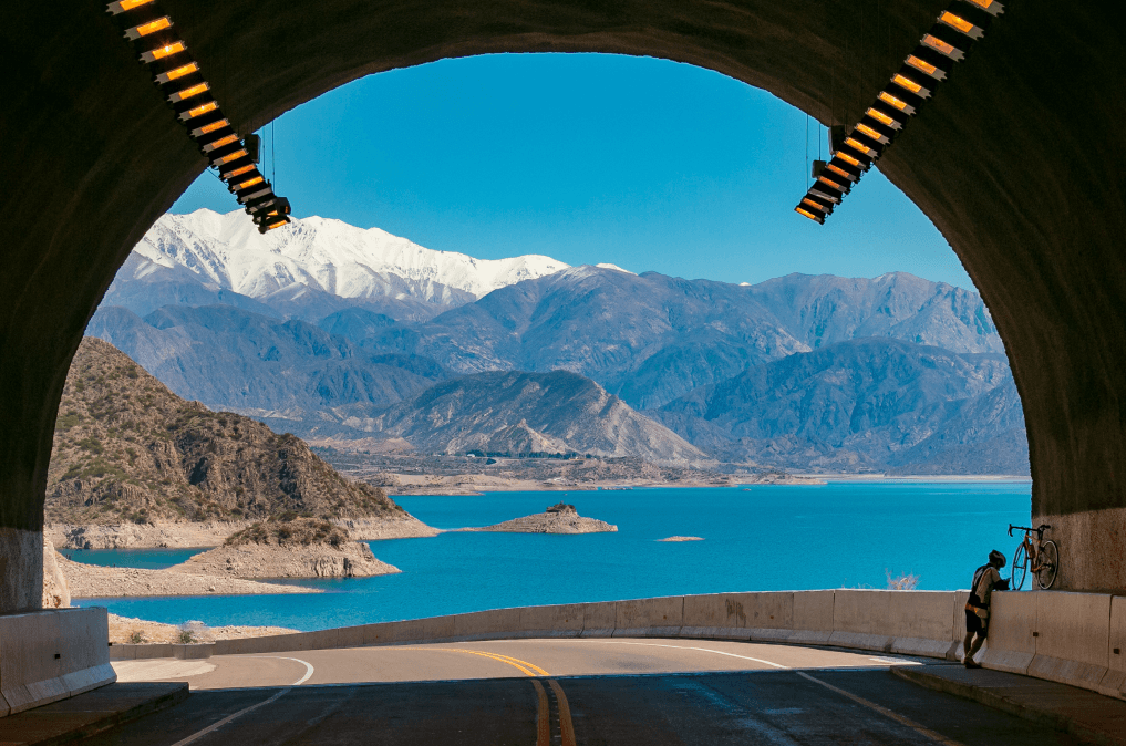 Túnel com o mar, montes verdes e montanhas com neve atrás em Mendoza.
