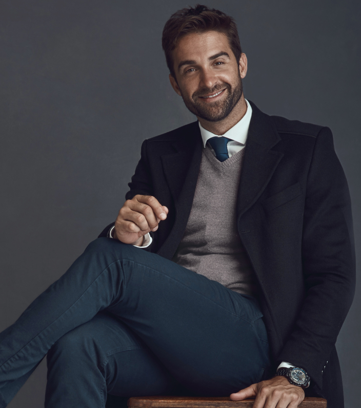 Homem grisalho com terno azul marinho segurando um celular