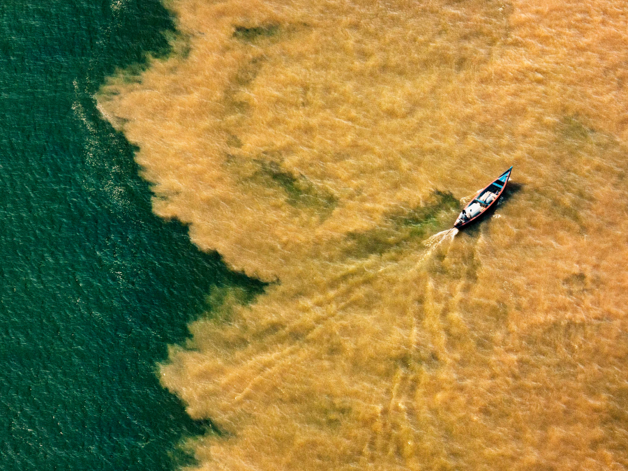 Foto de Canoa vista de cima navegando em um rio da Amazônia.