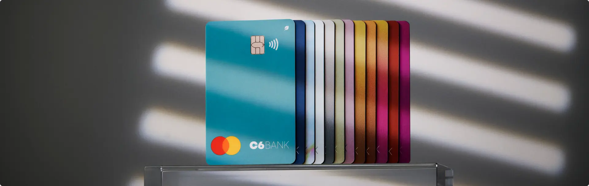 Leque Cartões Cartões C6 Bank coloridos em leque com destaque para a cor Acqua.